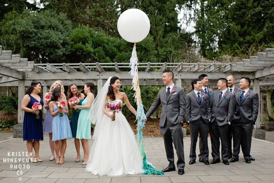 Bridal party with giant white balloon in shades of blue, aqua, mine, and turquoise at Seattle's Arboretum.