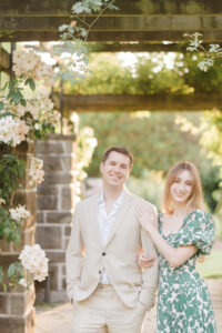 engaged couple link arms and smile